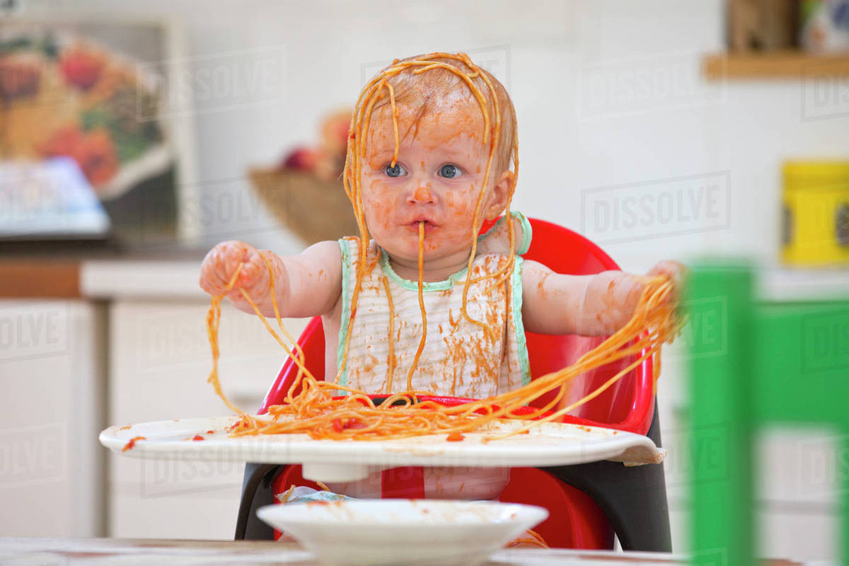 Baby Eating Spaghetti
 Messy Baby Boy Sits In High Chair Covered In Spaghetti And